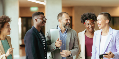 Employees in the office trusting and smiling with each other - Assertiveness Skills at Work - Win-Win Solutions for Daily Conflict