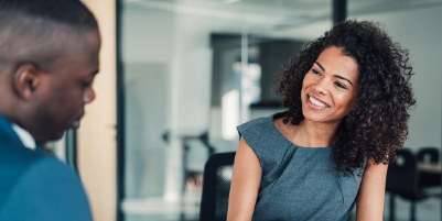 Young business woman smiling at business man in the office