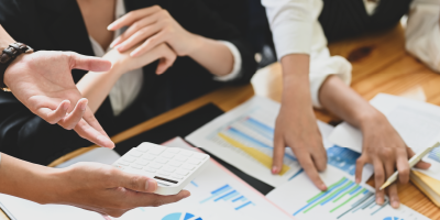 Business people are meeting together at the wooden working desk surrounded by paperwork. - Tableau for Data-Driven Decision Makers - Microsoft Project