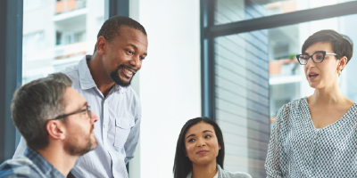 Cropped shot of a group of colleagues working together on a laptop in a modern office - self-confidence building - Leadership Communication