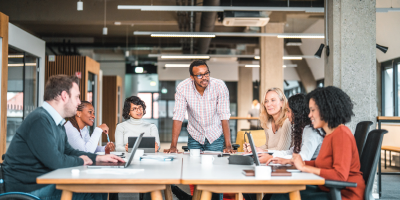 Bright open concept office. There is a work meeting being held where a group of diverse people, including a man on a wheelchair are working together. - effective leadership skills