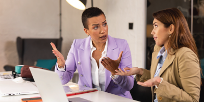 Photo of angry bossy business woman shout at irritated woman at work - dealing with difficult people