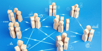 Wooden human figures connected by lines on a blue background, symbolizing organizational structure, change management, and team roles.