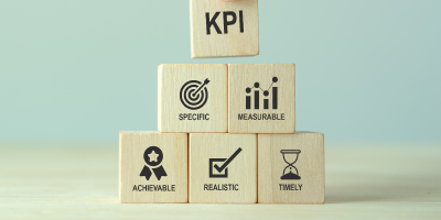 Concept of performance culture illustrated with building blocks representing effective and smart KPIs—specific, measurable, achievable, realistic, and timely—for tracking and evaluating progress.